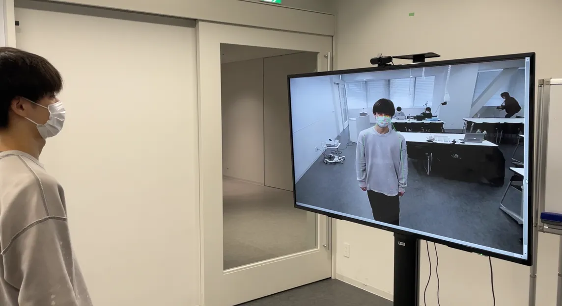 ポーズ検出のデモ。画面の前に立つと、カメラ映像に骨格が重ねて表示される