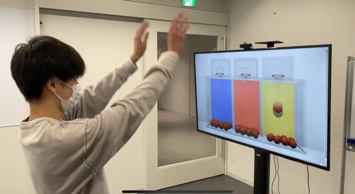 アンケート投票のデモ。画面の前でシュートのモーションをしている